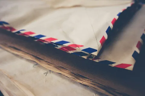 A stack of paper airmail envelopes with red and blue borders.