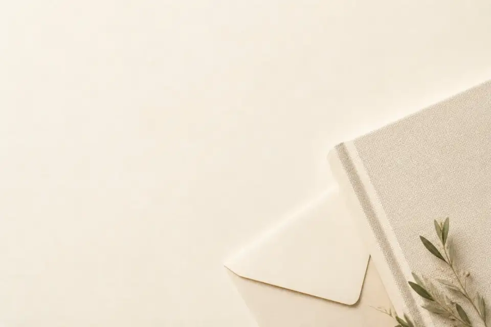 A keepsake book beside an envelope and an olive branch.